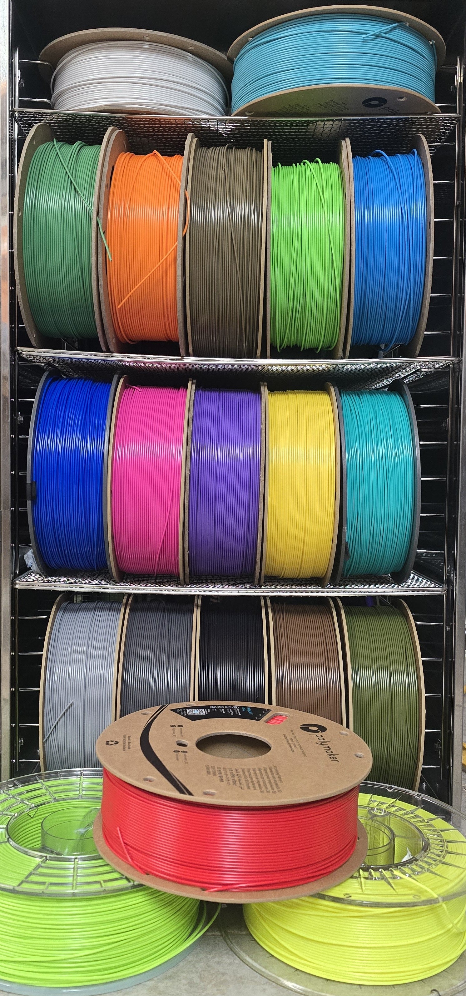 Colorful spools of filament on a metal rack